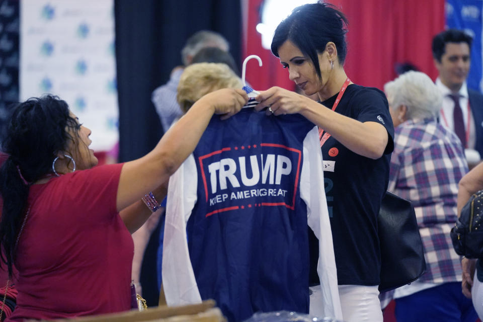 Ilona Hollosy Cooper, right, buys merchandise while attending the Conservative Political Action Conference (CPAC) in Dallas, Thursday, Aug. 4, 2022. Hungarian Prime Minister Viktor Orban is scheduled to speak at the conference Thursday and former President Donald Trump is scheduled for Saturday. (AP Photo/LM Otero)