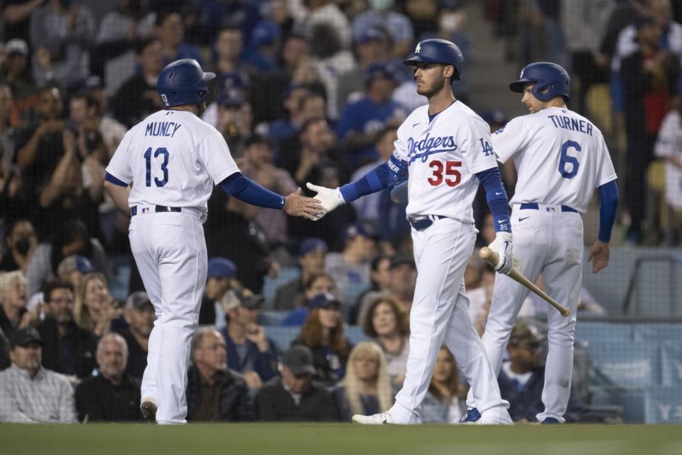 Dodgers' Cody Bellinger greets Max Muncy and Trea Turner, who scored on a two-run double by Will Smith.