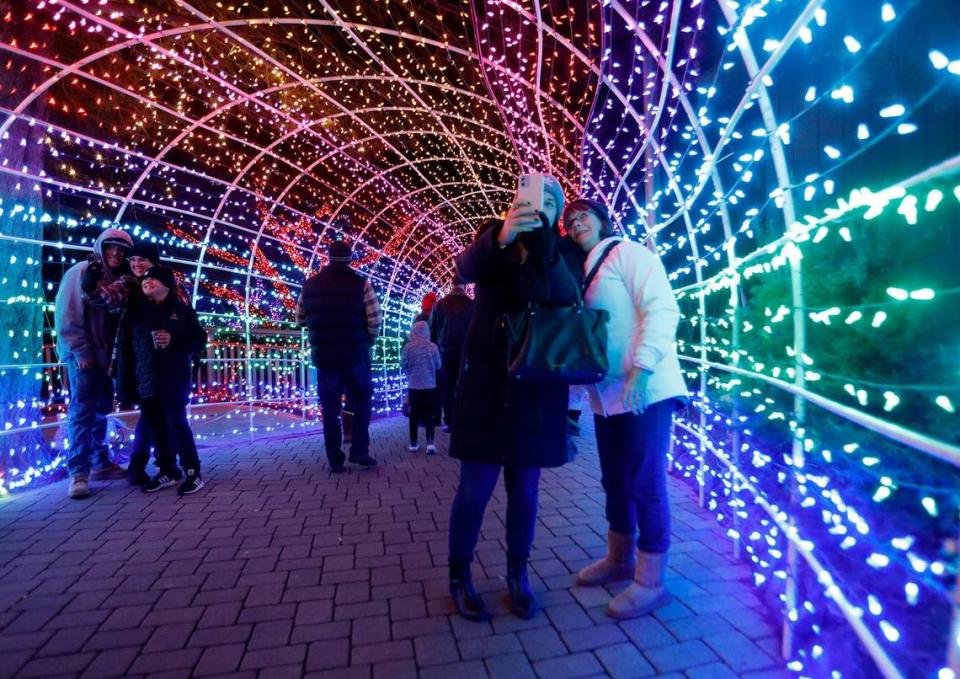 Visitors take selfies in the tunnel of lights at the Cambria Christmas Market in 2022. The tunnel has become an annual holiday symbol on the Central Coast.