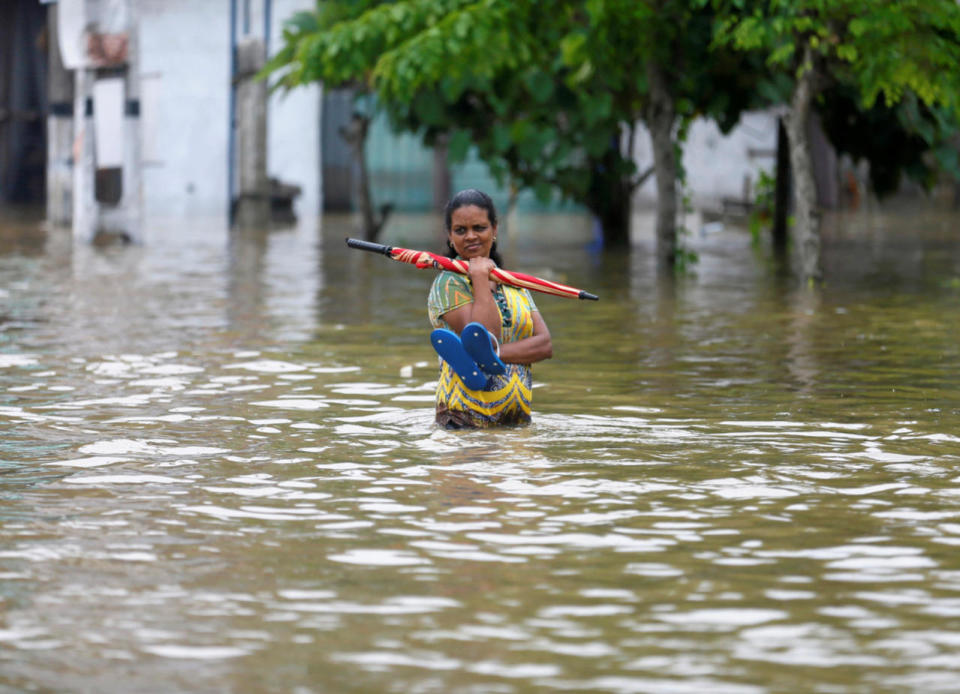 A woman on a flooded road in Biyagama, Sri Lanka, May 17, 2016. (Reuters/Dinuka Liyanawatte)