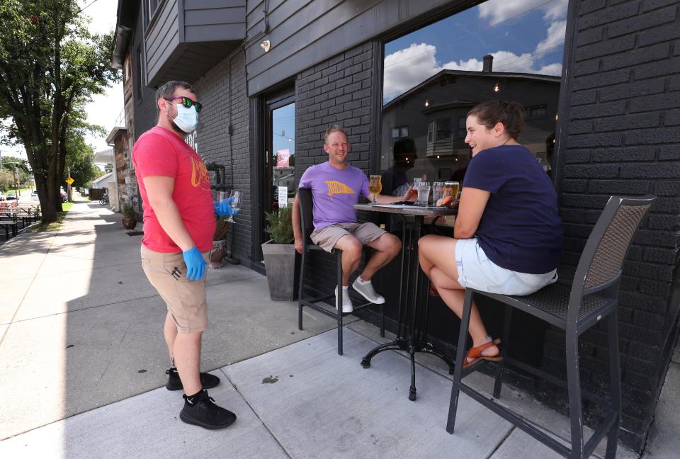 Bartender Patrick McKinney chats with Tom Duncan and Amy Curry as they experience outdoor dining at the Monnik Beer Co. in Louisville, Ky. Restaurants in Louisville will be allowed to expand outdoor dining into parking areas under a new Metro Government ordinance.