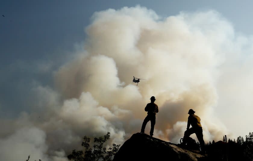 JANESVILLE, CALIF. - AUG. 189 2021. Firefighters watch a helicopter battle the Dixie Fire as it burns through mountainous and forested terrain near Janesville on Thursday, Aug. 19, 2021. (Luis Sinco / Los Angeles Times)