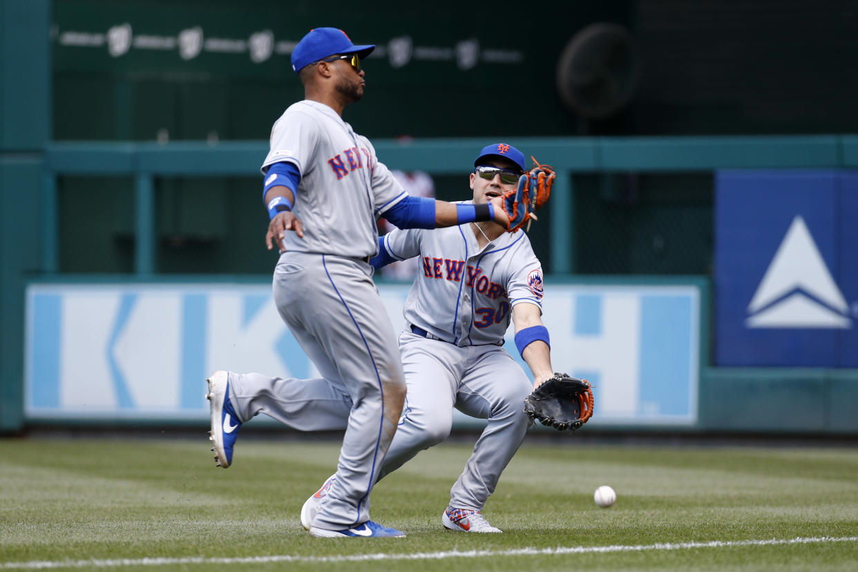 New York Mets right fielder Michael Conforto, right, collides with second baseman Robinson Cano as they fail to catch a fly ball that was hit by Washington Nationals' Howie Kendrick in the fifth inning of a baseball game, Thursday, May 16, 2019, in Washington. Conforto left the game after the play. (AP Photo/Patrick Semansky)