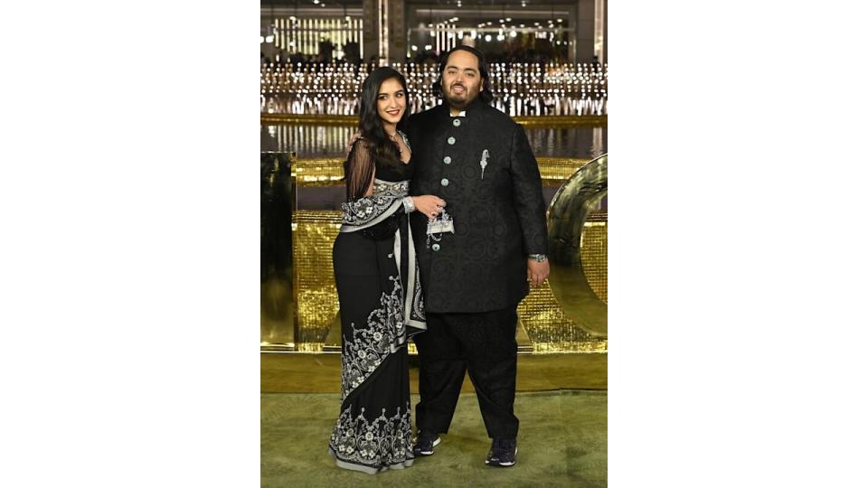 Anant Ambani in a black and white embroidered dress with Radhika Merchant