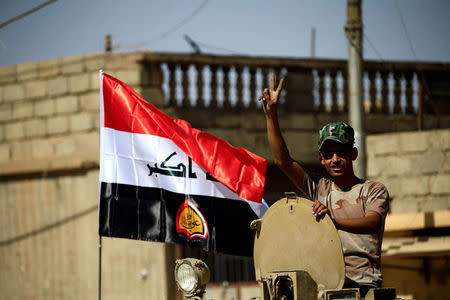 A member of Shi'ite Popular Mobilization Forces (PMF) flags victory sign during clashes against the Islamic State militants in Tal Afar, Iraq August 26, 2017. REUTERS/Thaier Al-Sudani