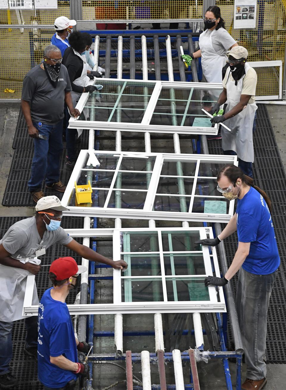 Workers assemble windows at PGT Innovations in 2021.
