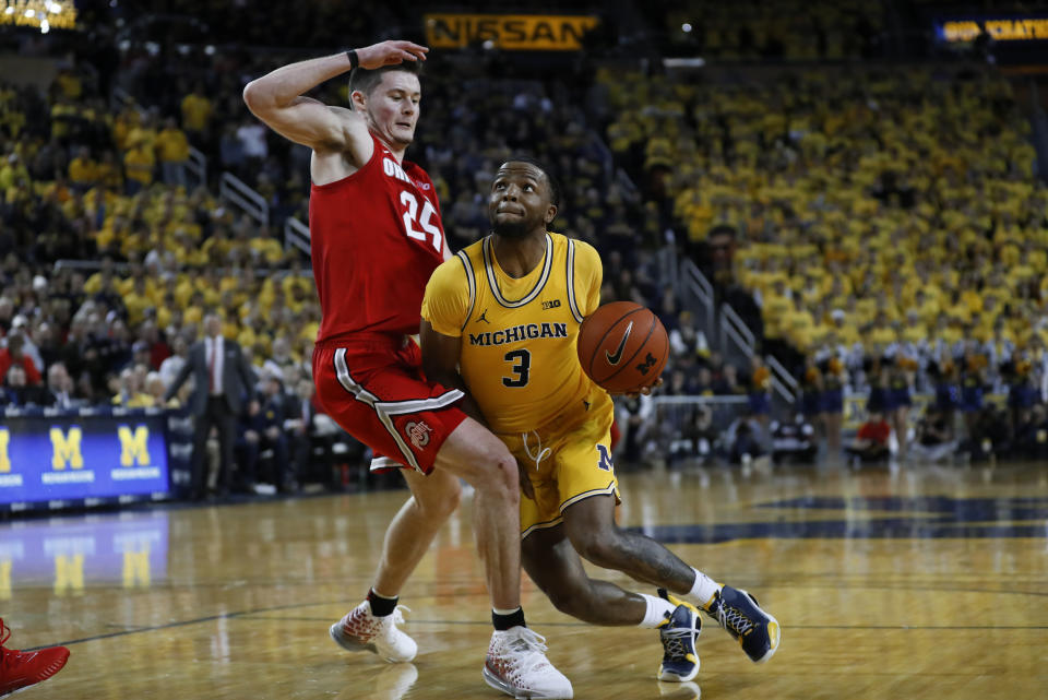 Michigan guard Zavier Simpson (3) drives on Ohio State forward Kyle Young (25) in the second half of an NCAA college basketball game in Ann Arbor, Mich., Tuesday, Feb. 4, 2020. (AP Photo/Paul Sancya)