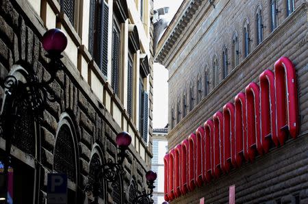 Twenty two rubber boats hang on the Palazzo Strozzi's facade (R) as part of the installation entitled "Reframe" by the Chinese artist Ai Weiwei in Florence, Italy September 21, 2016. REUTERS/Alessandro Bianchi