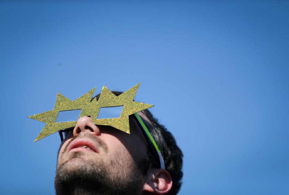 <p>A man uses protective glasses to watch a partial solar eclipse on March 20, 2015 in Berlin, Germany. (Photo: Kay Nietfeld/AFP/Getty Images) </p>