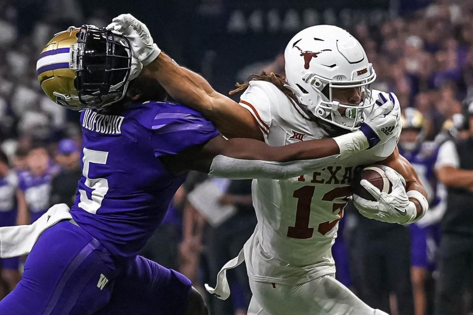 Texas Longhorns wide receiver Jordan Whittington (13) breaks a tackle by Washington linebacker Edefuan Ulofoshio (5) during the Sugar Bowl College Football Playoff semifinals game at the Caesars Superdome on Monday, Jan. 1, 2024 in New Orleans, Louisiana.