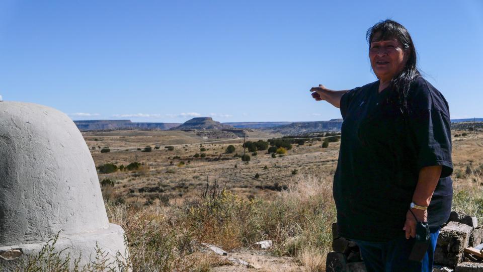 Arlene Juanico, 66, gestures toward Squirrel Mountain, the location of the Jackpile Mine, from the hill behind her childhood home in the village of Paguate, 60 miles west of Albuquerque.