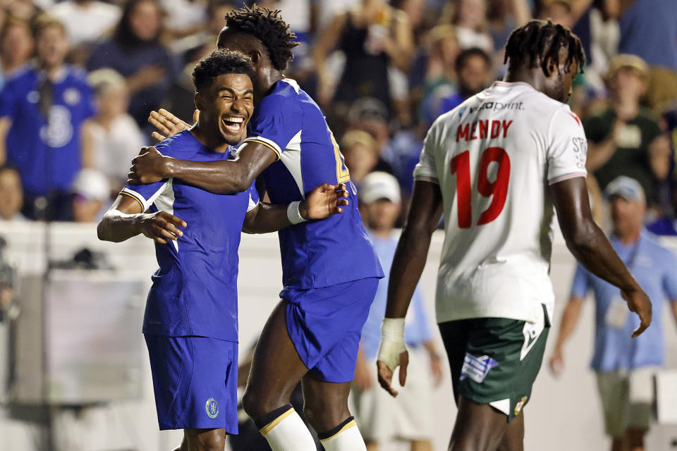 Chelsea's Ian Maatson, left, celebrates a goal with Nicolas Jackson, center, while Wrexham's Jacob Mendy (19) walks past during the first half of a club friendly soccer match Wednesday, July 19, 2023, in Chapel Hill, N.C. (AP Photo/Karl B DeBlaker)