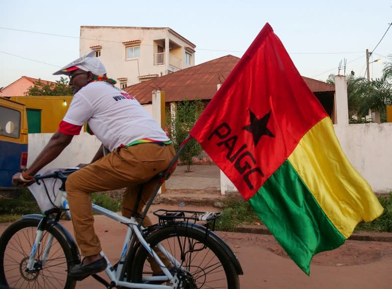 A supporter of presidential candidate Domingos Simoes Pereira rides a bicycle in Bissau