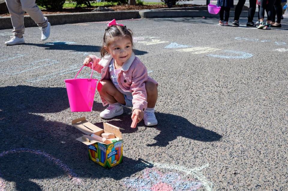 Sofia Meja, 3, draws with chalk during the Haggin Oaks Easter Egg Hunt on Sunday, April 9, 2023, in Sacramento.