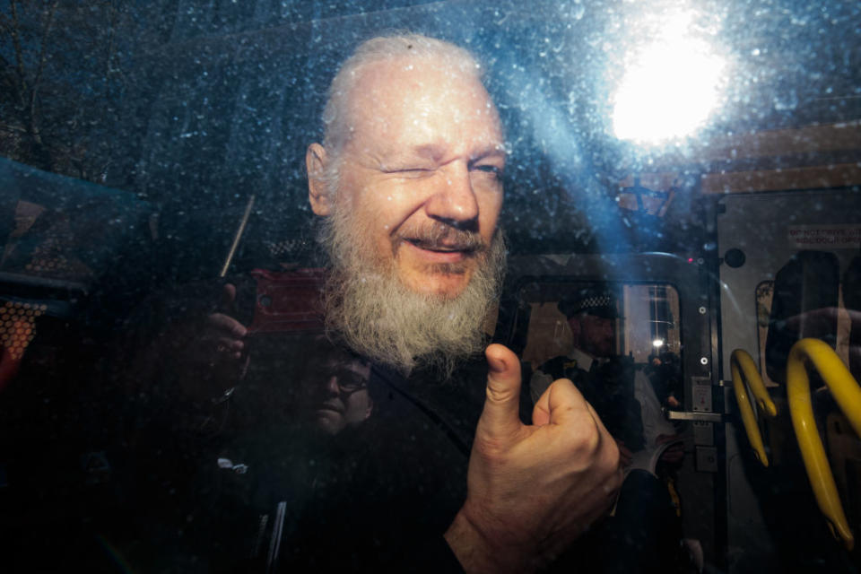 Julian Assange gestures to the media from a police vehicle on his arrival at Westminster Magistrates court on April 11, 2019 in London. Source: Getty Images