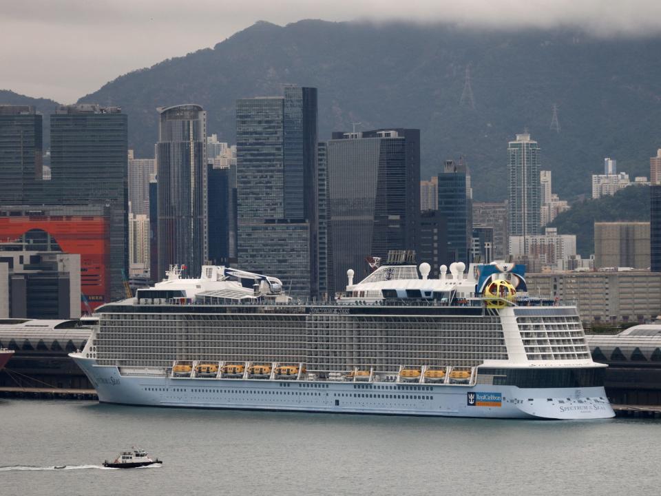 Royal Caribbean's Spectrum of the Seas cruise ship docked in Hong Kong in October 2021. Tall buildings line the background.