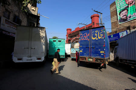 A policeman walks next to trucks, which used to block a venue of a planned protest gathering organised by Awami Muslim League, a political ally party of Imran Khan's Pakistan Tehreek-e-Insaf (PTI), in Rawalpindi, Pakistan, October 28, 2016. REUTERS/Faisal Mahmood