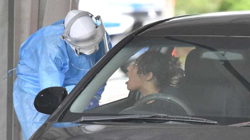A health care worker (left) is seen testing people at a Covid-19 drive through testing clinic at Murarrie in Brisbane.
