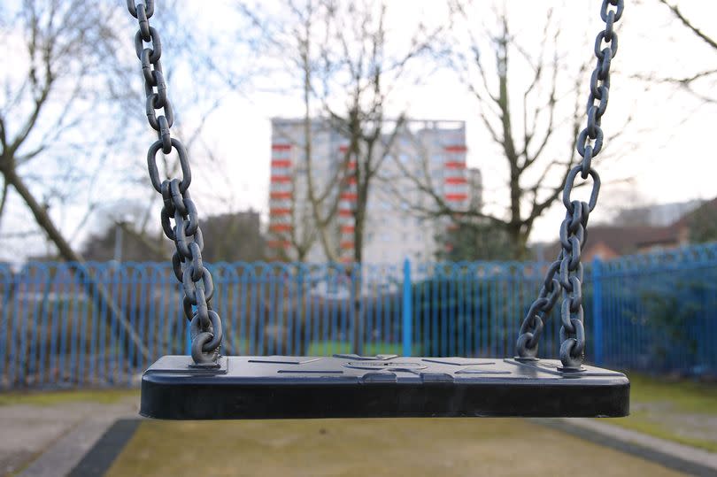 A file photo of an empty swing in a children's play area.