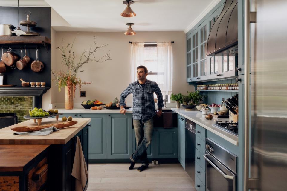 Harry Josh stands in his European countryside-style kitchen.