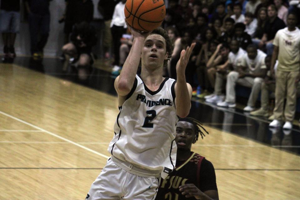 Providence guard Mason Lee (2) goes up for a basket in front of Florida High guard Thaddeus Burns (21) during Friday's FHSAA Region 1-3A high school boys basketball final.