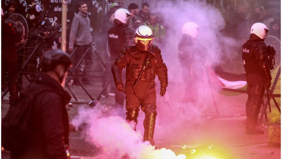 Protesters face riot place clash during an anti-coronavirus measures protest in Brussels Belgium, 21 November 2021. In a move to tackle yet another COVID-19 wave, the Belgian government imposed strict measures, pushing thousands to the streets to protest against mandatory vaccinations, health pass and anti-coronavirus measures.