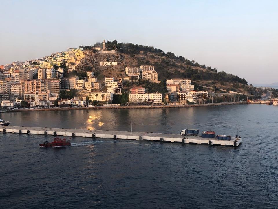 Image of Kusadasi Port, blue waters with a dock jutting out into it