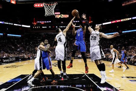 May 21, 2014; San Antonio, TX, USA; Oklahoma City Thunder guard Russell Westbrook (0) drives to the basket as San Antonio Spurs guard Danny Green (4) and forward Tiago Splitter (22) defend in game two of the Western Conference Finals of the 2014 NBA Playoffs at AT&T Center. Soobum Im-USA TODAY Sports