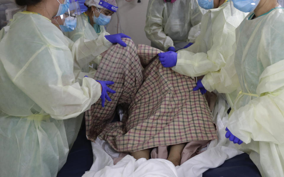 Medical personnel work with a COVID-19 patient at DHR Health, Wednesday, July 29, 2020, in McAllen, Texas. At DHR Health, the largest hospital on the border, roughly half of the 500 beds belong to coronavirus patients isolated in two units. A third unit is in the works. (AP Photo/Eric Gay)