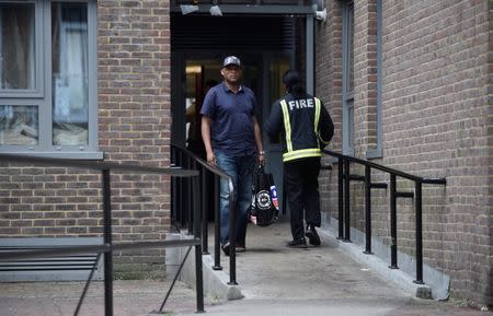 A resident is evacuated from the Taplow Tower residential block as a precautionary measure following concerns over the type of cladding used on the outside of the building on the Chalcots Estate in north London, Britain, June 24, 2017. REUTERS/Hannah McKay