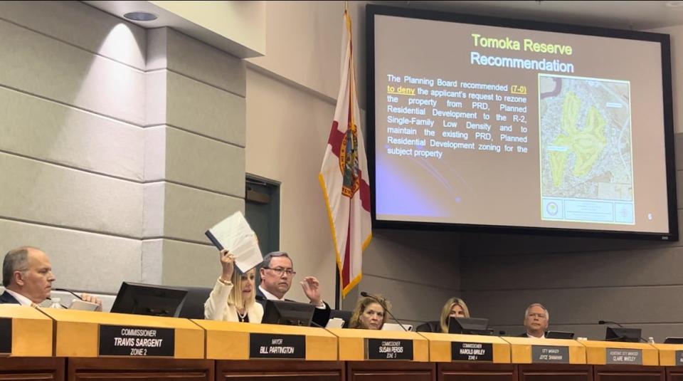 Ormond Beach City Commissioner Susan Persis holds up a report that Tomoka Oaks resident Carolyn Davis compiled on the community's history Tuesday night, April 16, 2024. The commission considered developers' application for a zoning map amendment to designate the former Sam Snead golf course at Tomoka Oaks as 
