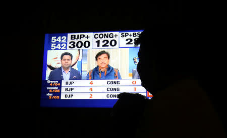 A man looks at a television screen showing exit poll results after the last phase of the general election in Ahmedabad, May 19, 2019. REUTERS/Amit Dave