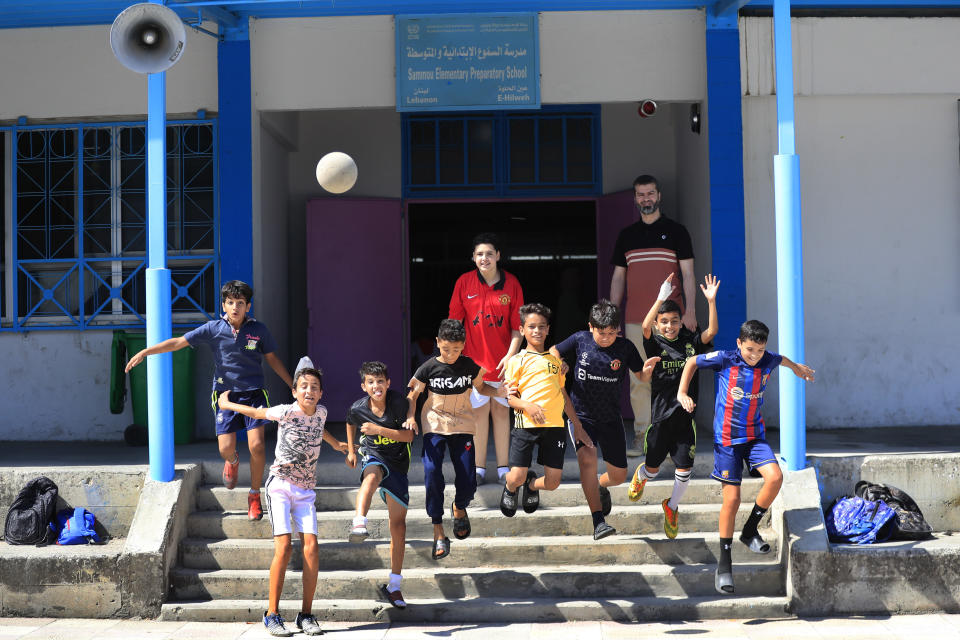 FILE - Palestinian boys jump during a soccer training session at a school run by the agency for Palestinian refugees, or UNRWA, at Ein el-Hilweh Palestinian refugee camp, in the southern port city of Sidon, Lebanon, on June 20, 2023. Two weeks after clashes between armed factions in Lebanon's largest Palestinian refugee camp ended, militants are still occupying a United Nations-run school complex, U.N. officials said Thursday Aug. 17, 2023. (AP Photo/Mohammed Zaatari, File)