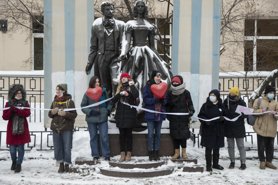 Women hold a white ribbon as they stay in a line during a rally in support of jailed opposition leader Alexei Navalny, and his wife Yulia Navalnaya in Moscow, Russia, Sunday, Feb. 14, 2021. The weekend protests in scores of cities last month over Navalny’s detention represented the largest outpouring of popular discontent in years and appeared to have rattled the Kremlin. (AP Photo/Pavel Golovkin)