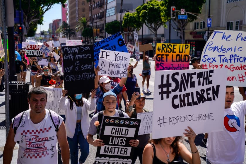 HOLLYWOOD, CA - JULY 31: Protesters make their way along Hollywood boulevard on Friday, July 31, 2020 in Hollywood, CA. Conspiracy theorists held the first "Child Lives Matter" protest in Hollywood to "expose" child trafficking, advertising the event with references to adrenochrome - a favorite topic of interconnected QAnon and Pizzagate conspiracy communities; and despite the so-called "adrenochrome harvesting" long predating these groups it has re-emerged during the Coronavirus pandemic. (Kent Nishimura / Los Angeles Times)