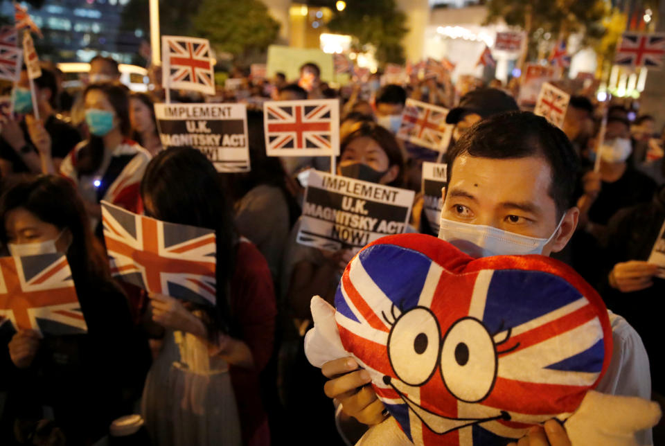 Anti-government demonstrators hold banners and Union Jack flags as they protest in front of the UK consulate in Hong Kong, China, October 23, 2019. REUTERS/Umit Bektas