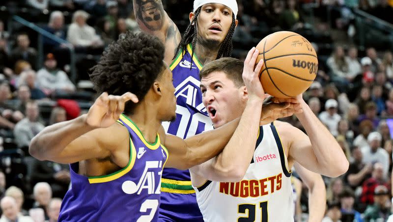 Utah Jazz guard Collin Sexton (2) and teammate Jordan Clarkson defend Denver guard Collin Gillespie during aJazz victory at the Delta Center in Salt Lake City on Wednesday, Jan. 10, 2024.