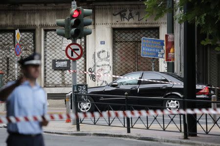 A police officer secures the area around the car of former Greek prime minister and former central bank chief Lucas Papademos following the detonation of an envelope injuring him and his driver, in Athens, Greece, May 25, 2017. REUTERS/Costas Baltas