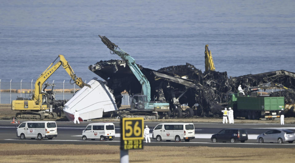 A removal work is underway at the site of a planes collision at Haneda airport in Tokyo Friday, Jan. 5, 2024. Cranes were dismantling the Japan Airlines Flight 516 Airbus A350 that caught fire after hitting a Coast Guard aircraft while it was landing Tuesday at the airport. (Kyodo News via AP)