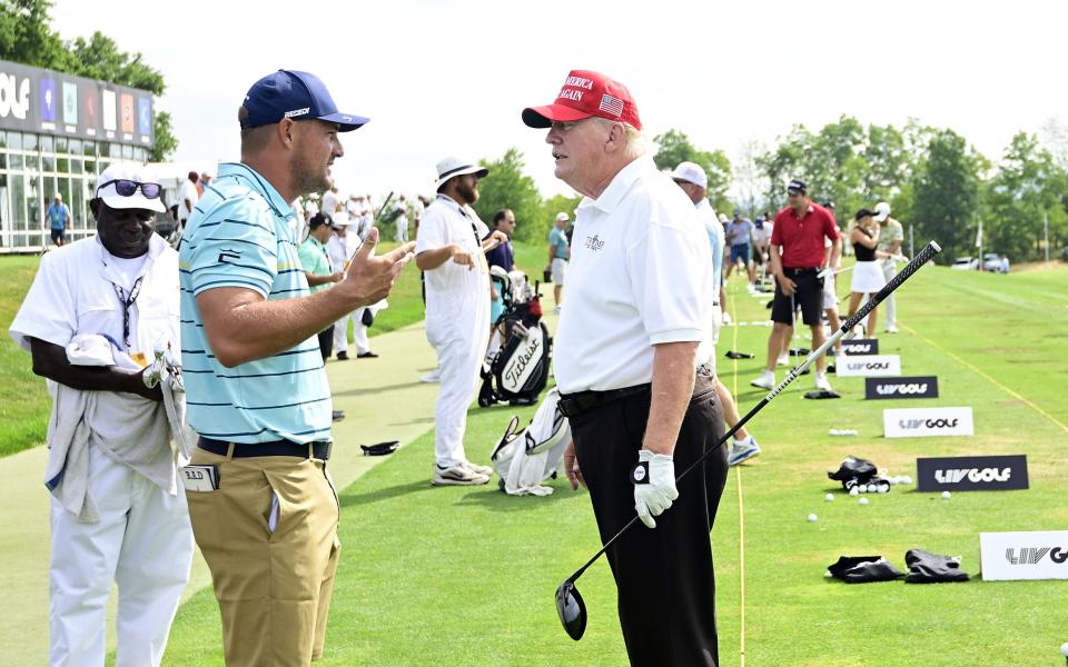 Donald Trump with Bryson DeChambeau (left) on the practice range - GETTY IMAGES