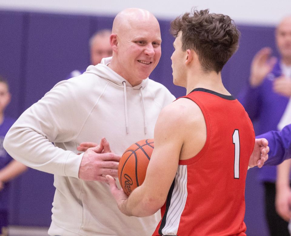 Former Jackson boys basketball star Jami Bosley (left) embraces his son, Maxx Bosley, after he set the Wadsworth career scoring record at Jackson on Tuesday, Feb.13, 2024.