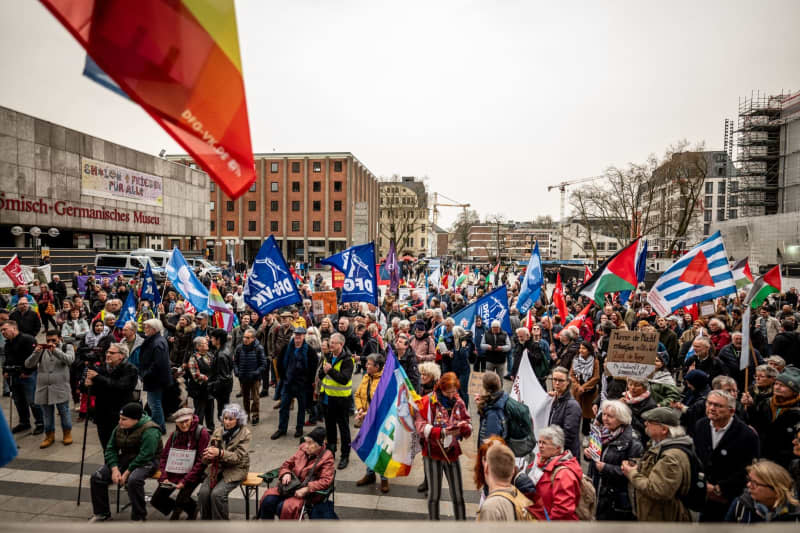 Les gens se rassemblent sur la Roncalliplatz pour la marche de Pâques sous le slogan "Pour un redressement civil – mettez fin aux guerres, arrêtez le réarmement !".  Christian Knieps/dpa