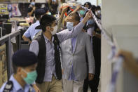 Hong Kong media tycoon Jimmy Lai, center, is escorted by police inside the Apple Daily newspaper headquarters in Hong Kong Monday, Aug. 10, 2020. Police arrested Lai and raided the newspaper's headquarters Monday in the highest-profile use yet of the new national security law Beijing imposed on the city in June. (Apple Daily via AP)