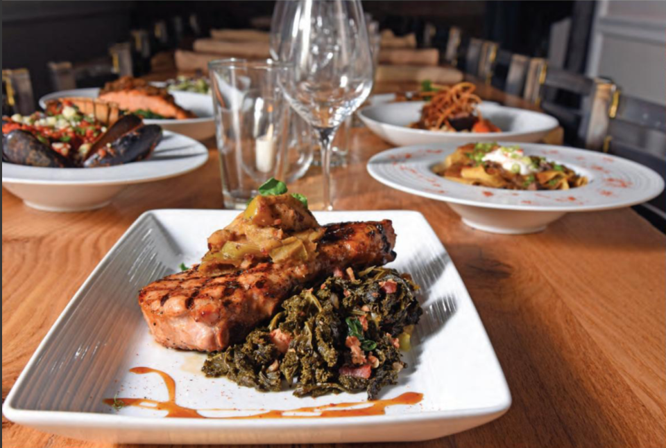 The grilled prime pork chop at Morning Fork/Fork & Barrel restaurant in Louisville is served with compound butter, braised kale and au gratin potatoes.