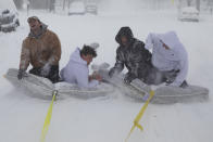 Brothers of the Phi Gamma Delta Fraternity pull their friends on mattresses along the street in front of the UNL Union during a winter storm in downtown Lincoln, Neb. on Monday, Jan. 25, 2021. (Kenneth Ferriera/Lincoln Journal Star via AP)