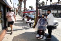 Keith Huerta, 30, cuts the hair of Nick Parr, 25, on the street outside Active Barbers, amid the global outbreak of the coronavirus disease (COVID-19), in Santa Monica