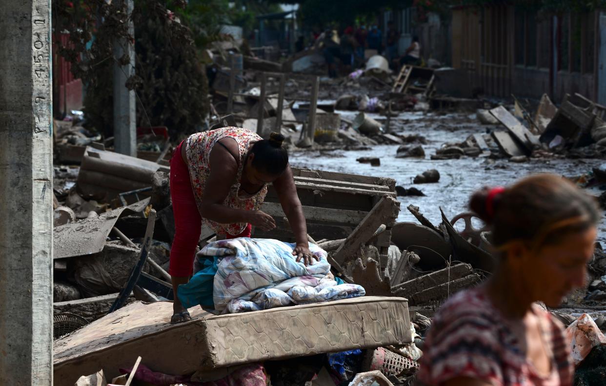 Women try to recover belongings after the passage of Hurricane Eta at the Omonita neighborhood in El Progreso, Yoro department, Honduras, On November 15 2020, before the arrival of Hurricane Iota. - Hurricane Iota is forecast to strengthen to an "extremely dangerous" Category Four by the time it makes landfall in Central America on Monday, the US National Hurricane Center warned, two weeks after powerful storm Eta devastated much of the region and left more than 200 people dead or missing. (Photo by Orlando SIERRA / AFP) (Photo by ORLANDO SIERRA/AFP via Getty Images)