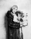 <p>Silent film star, Dolores Del Río, wears a mink fur coat and carries presents in 1925. The Mexican actress decorated her parcels with tulle ribbon and festive holly sprigs. </p>