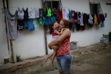 Gabriela Alves de Azevedo, 22, holds her two-year-old daughter Ana Sophia, who was born with microcephaly, at their house in Olinda, Brazil, August 7, 2018. Gabriela had planned to finish high school and study physical therapy. Now, she spends her days caring for her child. Her husband left shortly after Ana Sophia's birth. He could not accept their child's condition, Gabriela says, and does not pay child support. "I went into depression and my family helped me," she said. "If it was not for them, I would have gone crazy." REUTERS/Ueslei Marcelino/Files