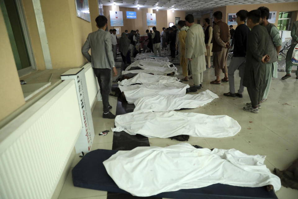 Afghan men try to identify the dead bodies at a hospital after a bomb explosion near a school west of Kabul, Afghanistan, Saturday, May 8, 2021. A bomb exploded near a school in west Kabul on Saturday, killing several people, many them young students, an Afghan government spokesmen said. (AP Photo/Rahmat Gul)